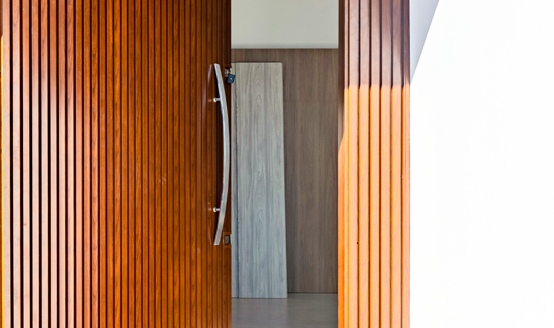 Fotografia ilustrativa de uma porta com painel ripado em aluminio